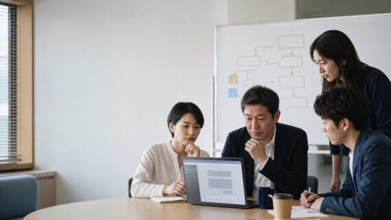 中小企業の会議室で、社員がAI活用と業務フローを話し合っている様子